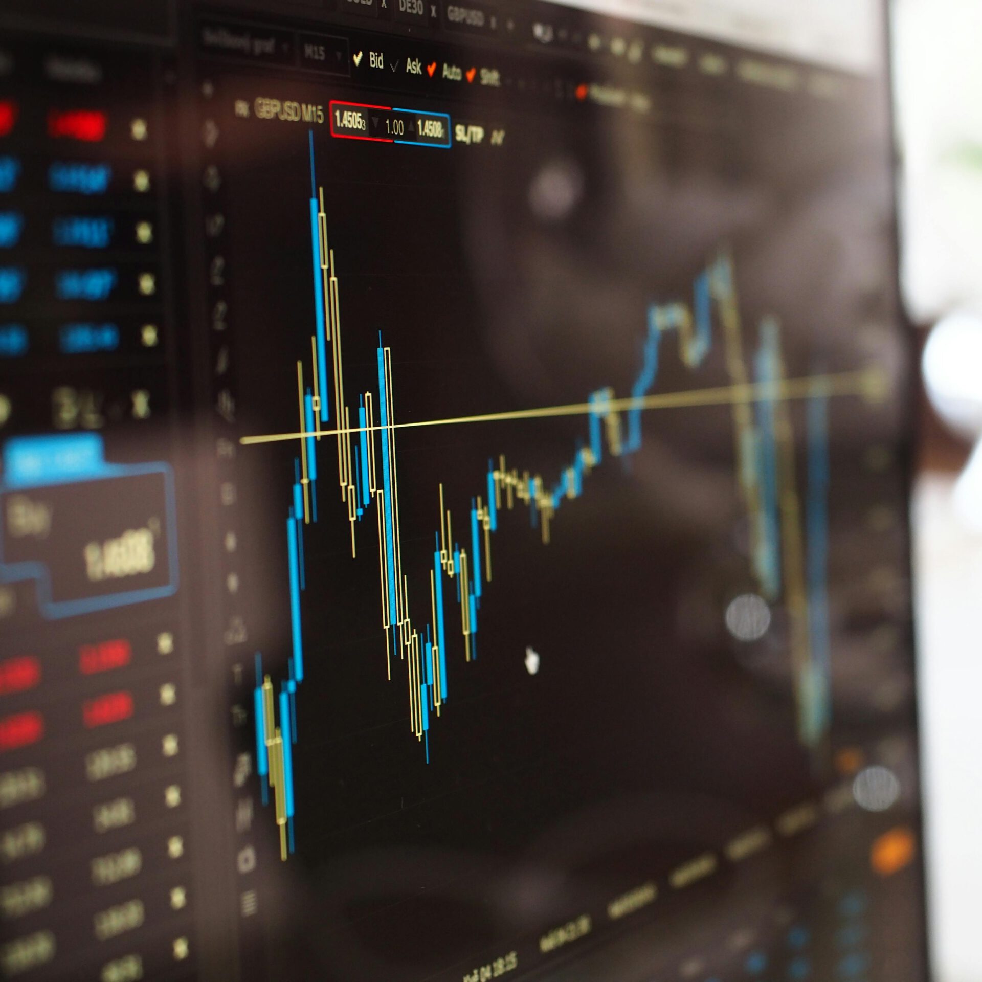 Detailed view of financial trading graphs on a monitor, illustrating stock market trends.
