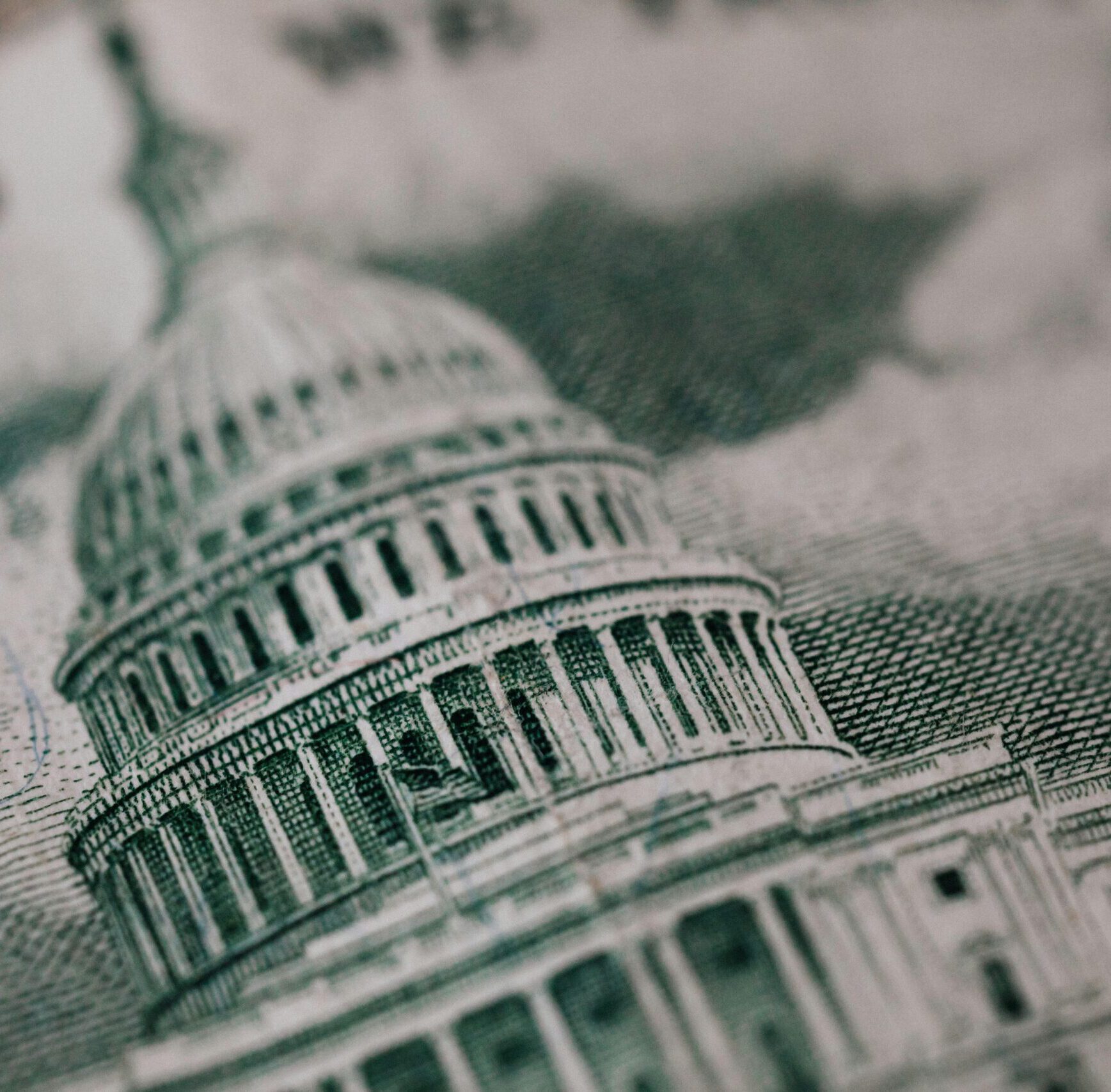 Close-up of the US Capitol illustration on American currency, showing detailed architectural design.